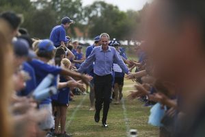Principal Dale Burden is cheered by students at a sports day