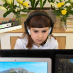Young girl with headphones following an online class/lesson