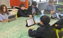 Students working on tablets at recycled plastic desk