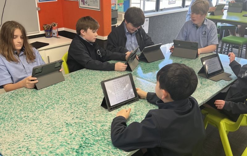 Students working on tablets at recycled plastic desk