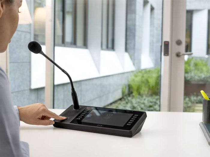 A lady using a IP audio solution to interface with a PA solution